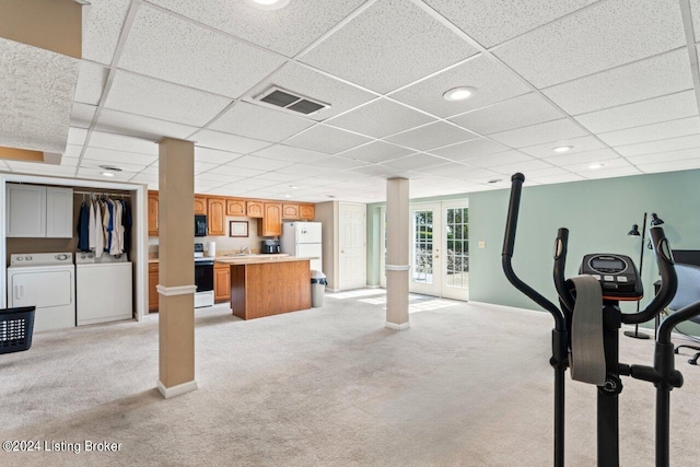 workout area featuring light carpet, washing machine and dryer, and french doors