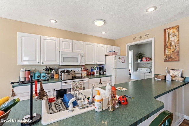 kitchen featuring white cabinetry, kitchen peninsula, white appliances, separate washer and dryer, and a textured ceiling