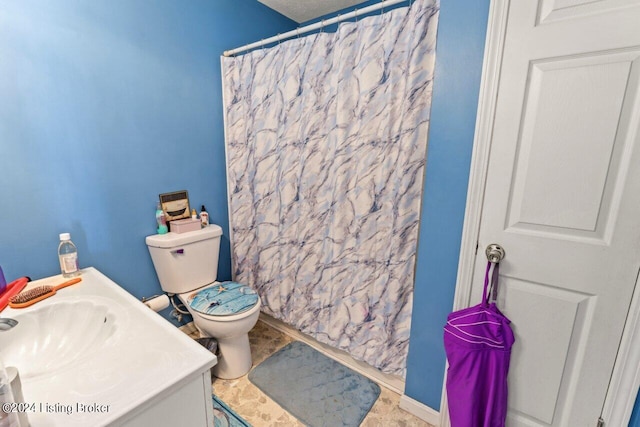 bathroom featuring toilet, walk in shower, and vanity