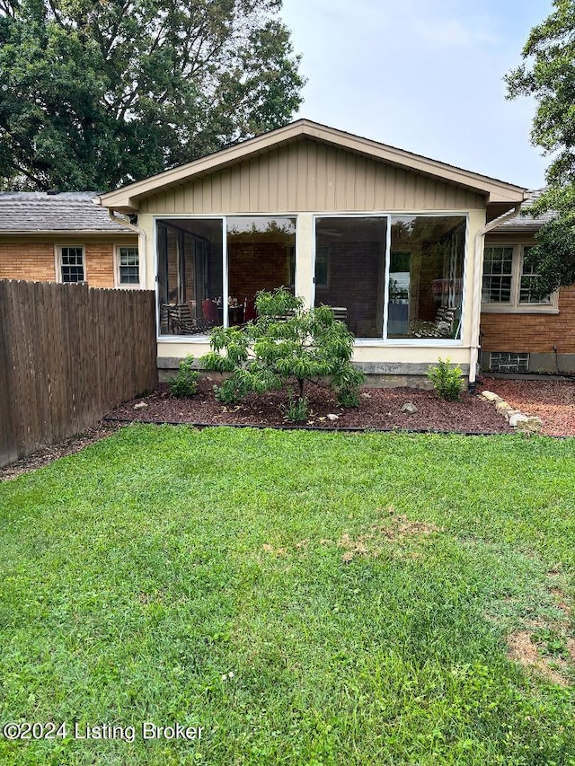 view of front of house featuring a sunroom and a front lawn