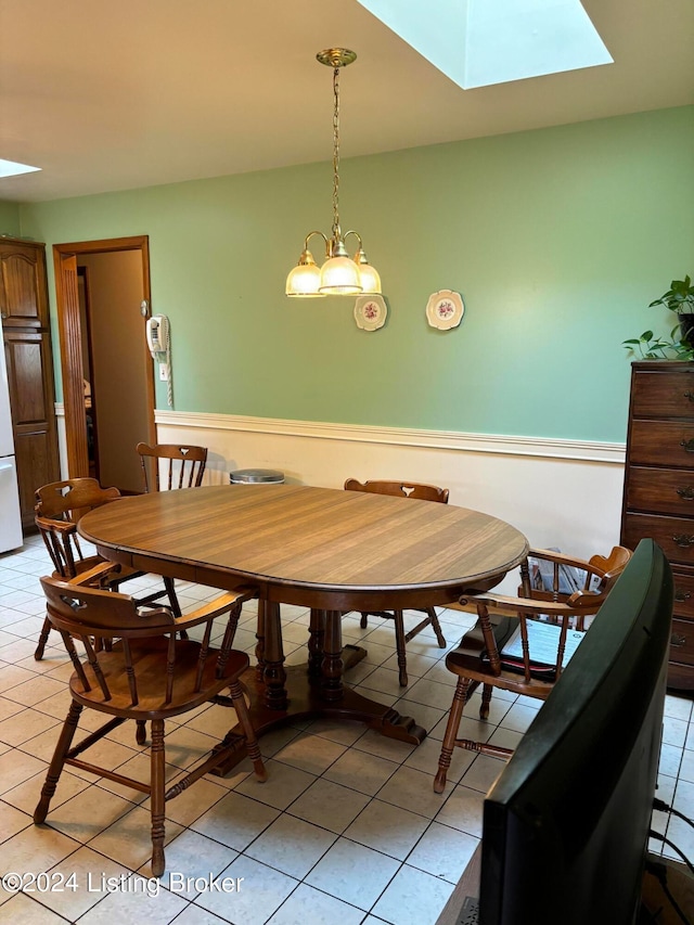 dining room with a skylight and light tile patterned floors