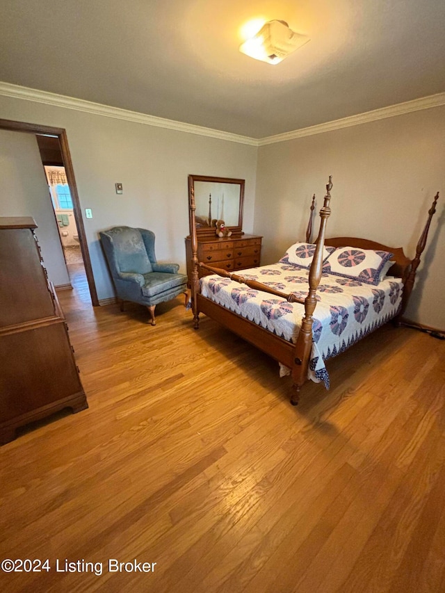 bedroom with ornamental molding and light hardwood / wood-style floors