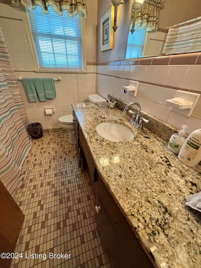 bathroom with vanity, tile walls, decorative backsplash, toilet, and tile patterned flooring