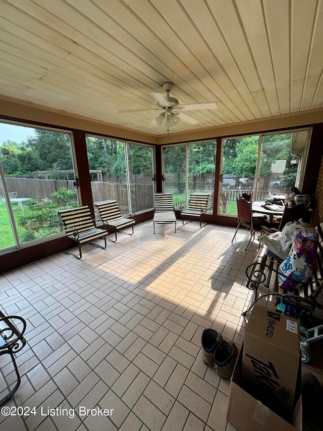 unfurnished sunroom with wood ceiling and ceiling fan