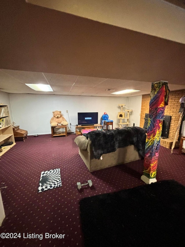 game room with brick wall, carpet, and a paneled ceiling