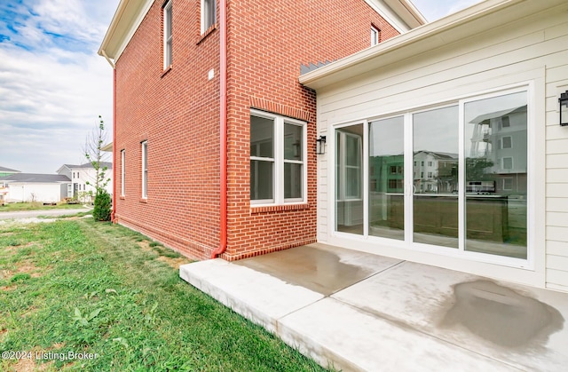 view of side of home featuring a patio and a lawn