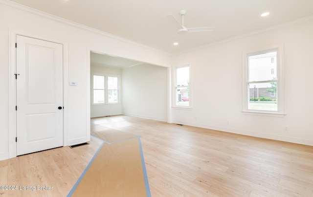 empty room with ornamental molding, ceiling fan, and light wood-type flooring