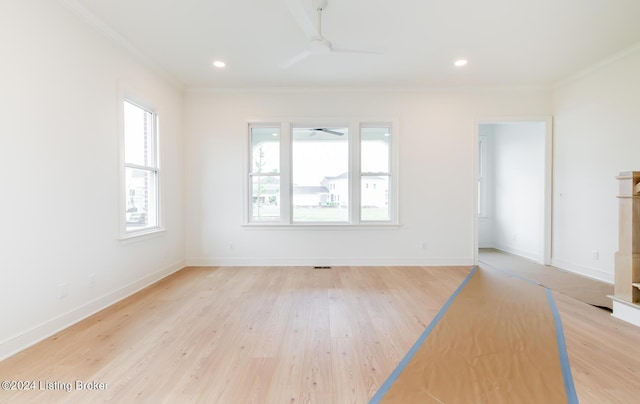 spare room with crown molding, ceiling fan, and light wood-type flooring