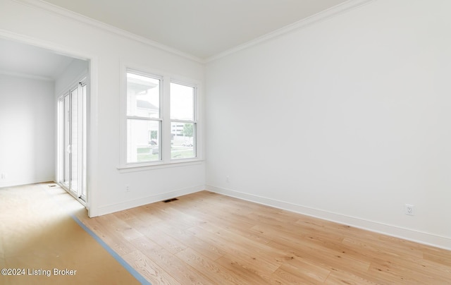 spare room featuring crown molding and light hardwood / wood-style flooring