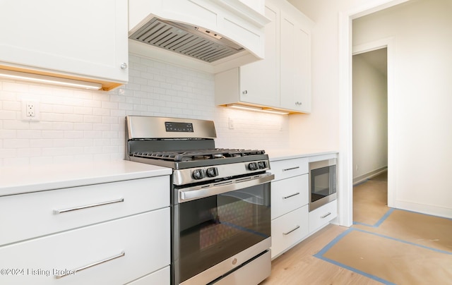 kitchen with light hardwood / wood-style flooring, stainless steel appliances, custom range hood, white cabinets, and decorative backsplash