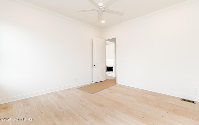 empty room featuring ornamental molding, ceiling fan, and light hardwood / wood-style floors