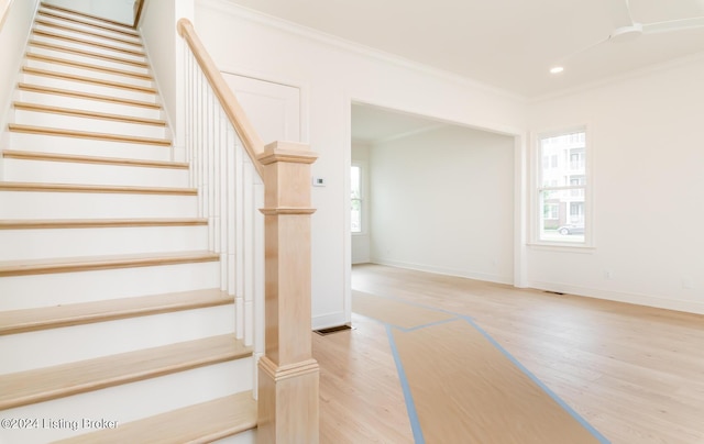 staircase with crown molding and hardwood / wood-style flooring