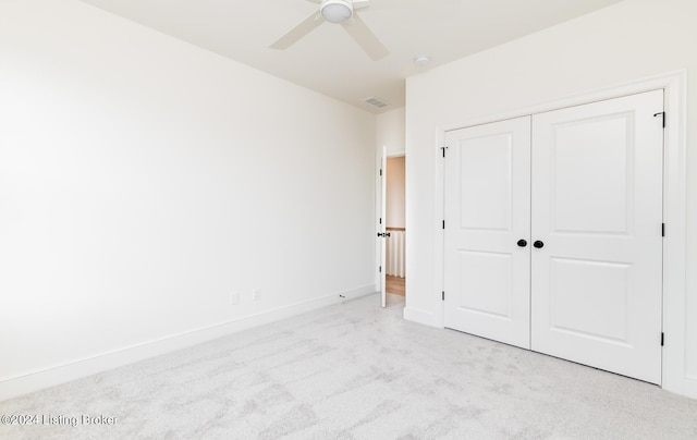 unfurnished bedroom with ceiling fan, light colored carpet, and a closet