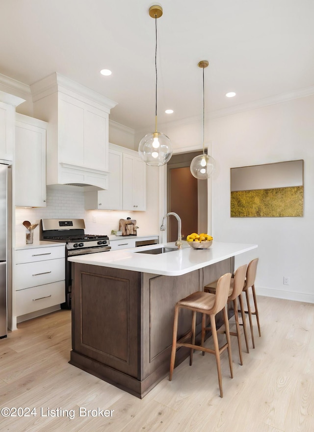 kitchen featuring white cabinetry, appliances with stainless steel finishes, sink, and a kitchen island with sink