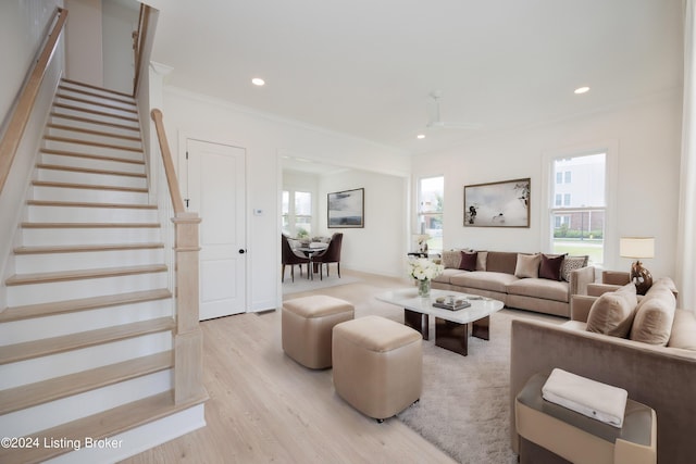 living room with light hardwood / wood-style flooring, ornamental molding, and ceiling fan