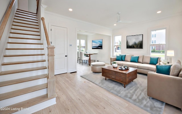 living room with ornamental molding and light wood-type flooring