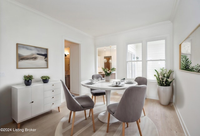 dining space featuring ornamental molding and light hardwood / wood-style floors