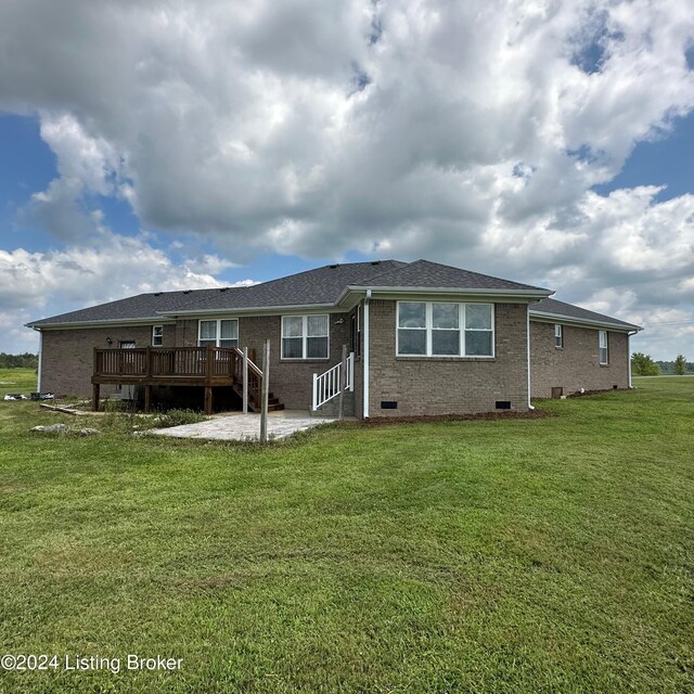 rear view of property with a wooden deck and a lawn