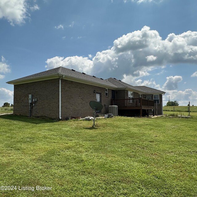 back of property with a deck, a lawn, and cooling unit