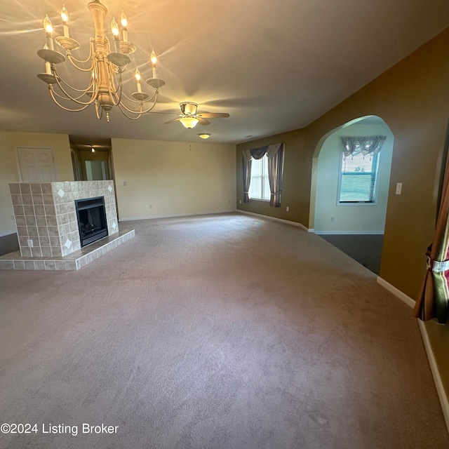 27 Jenkins Rd, Rineyville, KY 40162 - unfurnished living room with carpet, baseboards, a fireplace, arched walkways, and ceiling fan with notable chandelier