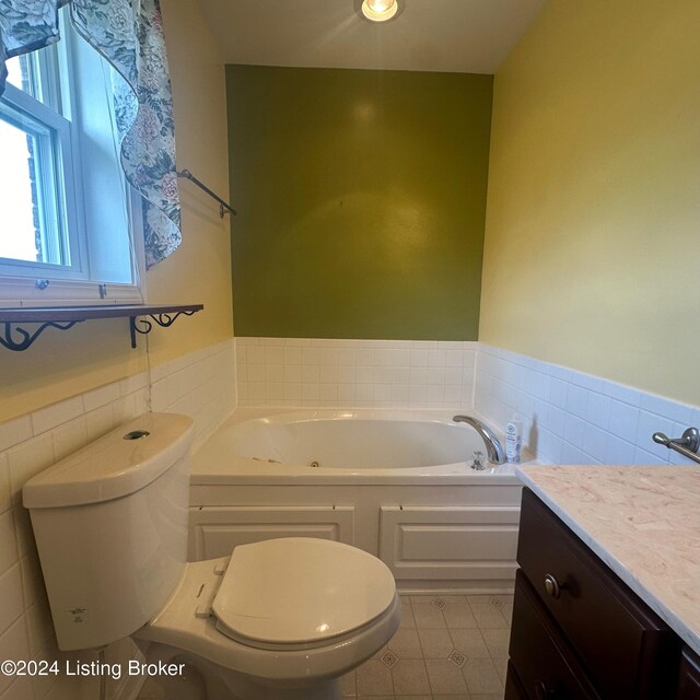 bathroom with tile walls, a washtub, vanity, and toilet