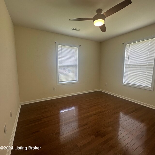 empty room featuring ceiling fan and dark hardwood / wood-style flooring