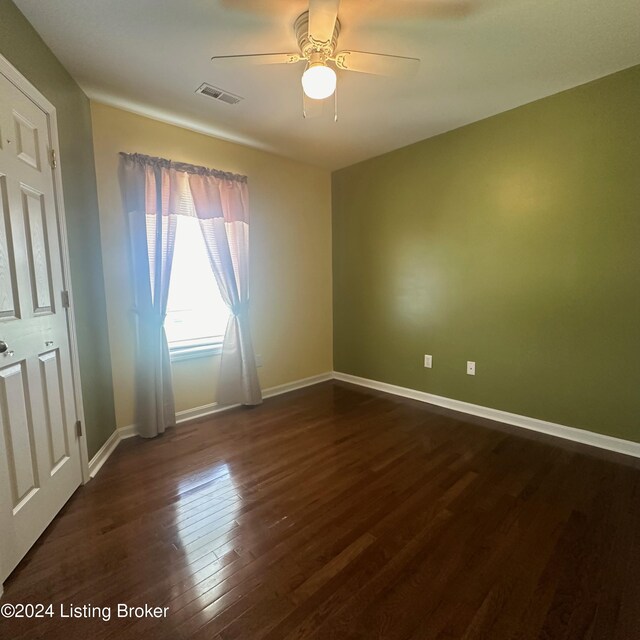 spare room featuring dark hardwood / wood-style flooring and ceiling fan