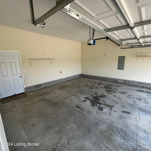 garage with a garage door opener and electric panel