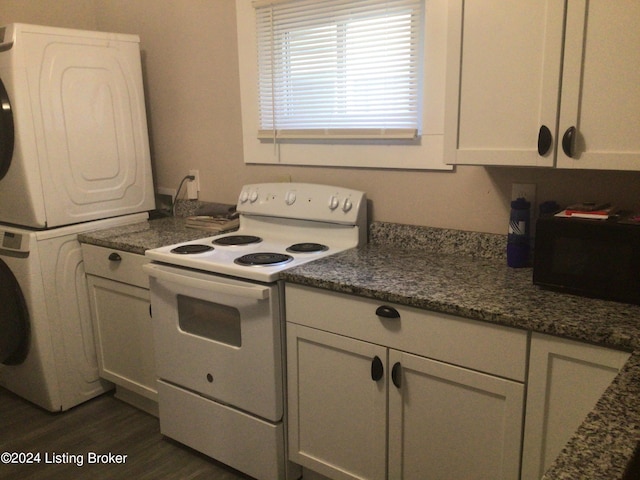 kitchen with dark hardwood / wood-style flooring, stacked washing maching and dryer, white range with electric stovetop, and dark stone countertops