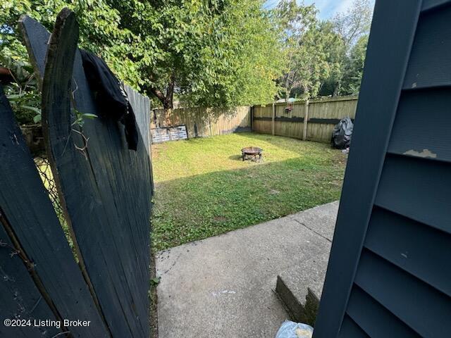 view of yard with an outdoor fire pit and a fenced backyard