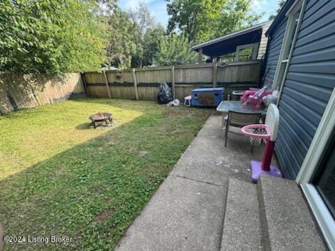 view of yard with an outdoor fire pit, a fenced backyard, and a patio