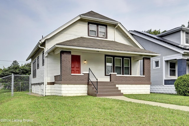 bungalow with covered porch and a front lawn