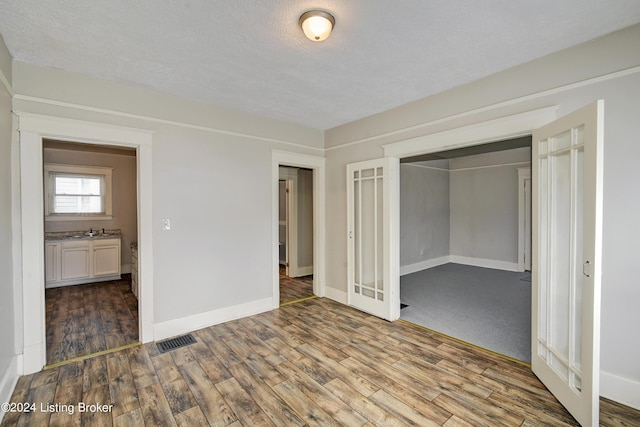 unfurnished bedroom featuring sink, dark hardwood / wood-style flooring, and a closet