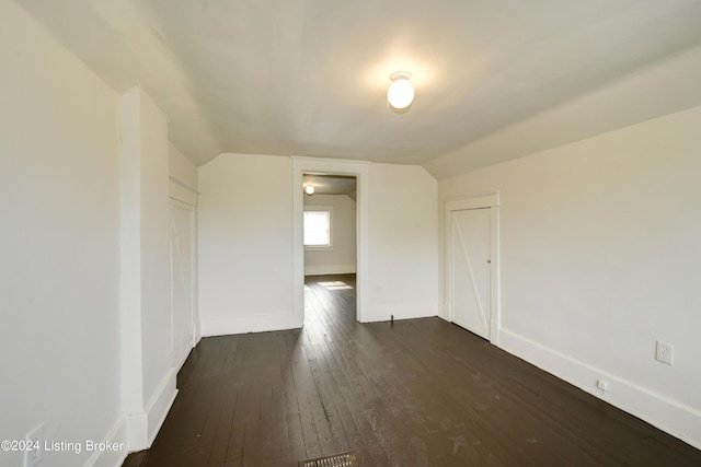 empty room with lofted ceiling and dark hardwood / wood-style floors