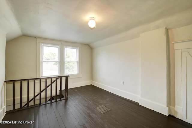 bonus room featuring vaulted ceiling and dark wood-type flooring