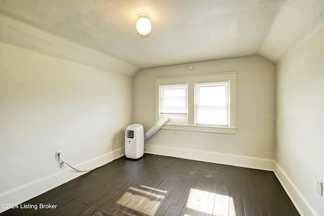 additional living space featuring dark wood-type flooring and lofted ceiling