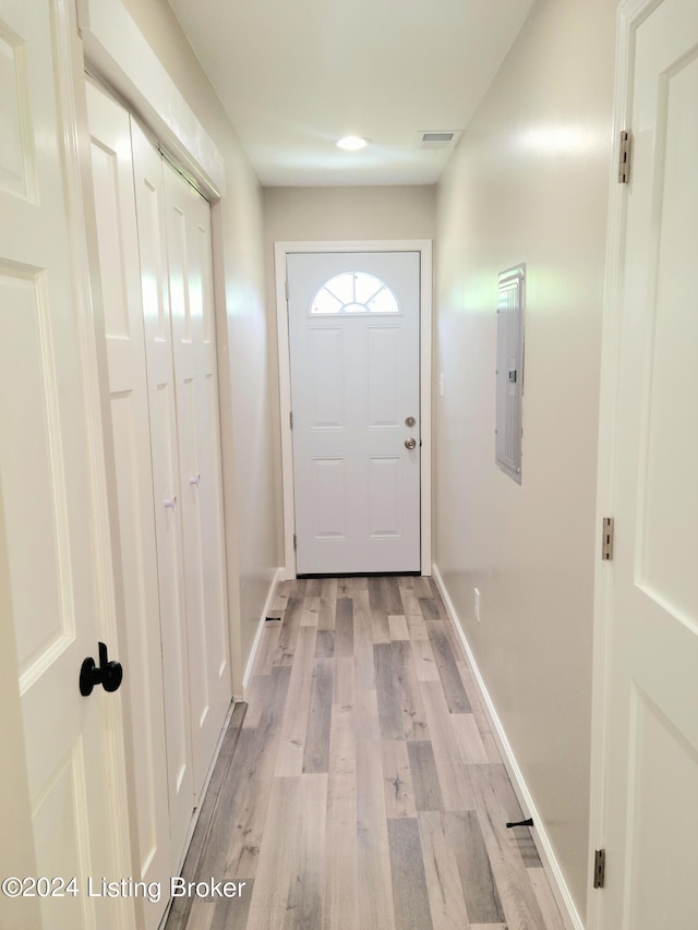 doorway to outside featuring electric panel and light hardwood / wood-style floors