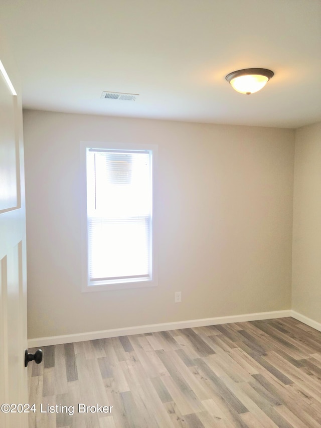 unfurnished room featuring a wealth of natural light and wood-type flooring