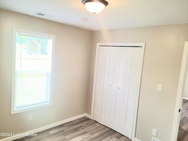 unfurnished bedroom featuring wood-type flooring and a closet