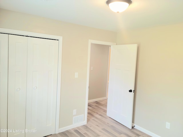 unfurnished bedroom featuring a closet and light hardwood / wood-style flooring