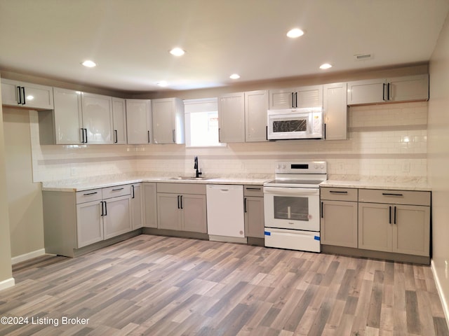 kitchen featuring gray cabinetry, sink, white appliances, and light hardwood / wood-style floors