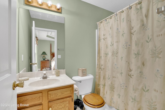 bathroom with vanity, curtained shower, and toilet