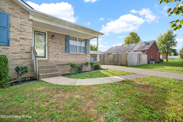 view of side of home featuring central AC and a lawn