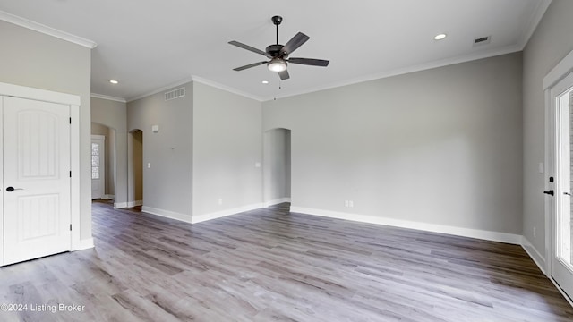 empty room with a wealth of natural light, ornamental molding, light hardwood / wood-style floors, and ceiling fan