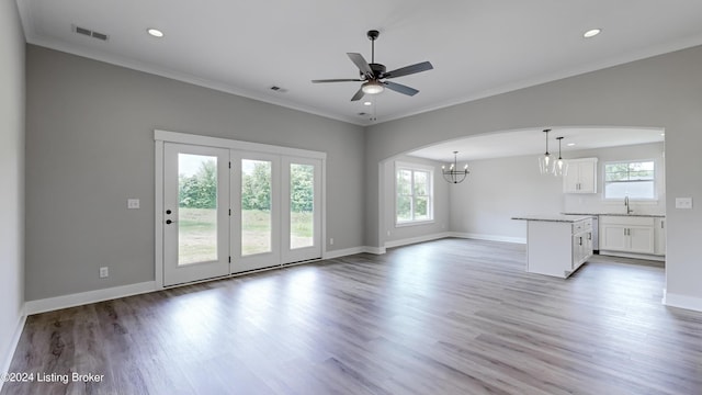 unfurnished living room with crown molding, sink, and hardwood / wood-style floors