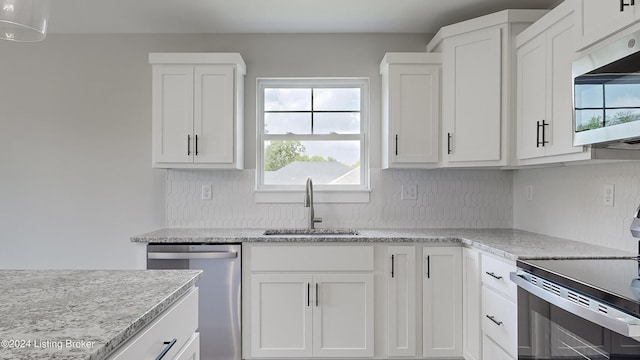 kitchen featuring sink, white cabinetry, appliances with stainless steel finishes, light stone countertops, and decorative backsplash