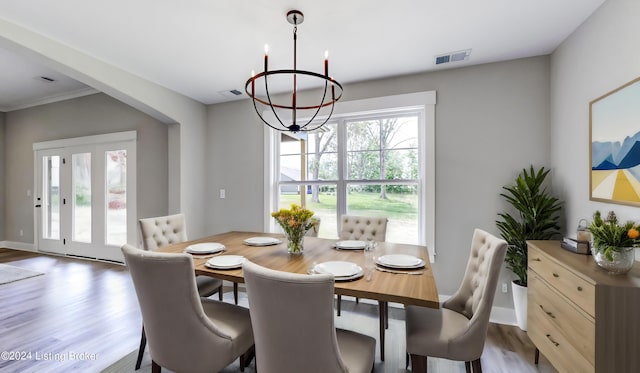 dining space featuring wood-type flooring and a notable chandelier