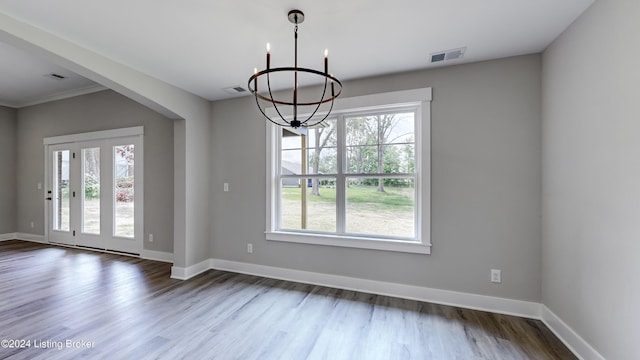 unfurnished dining area with hardwood / wood-style flooring and a chandelier