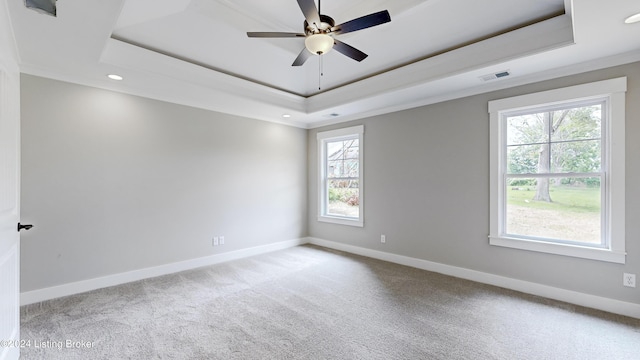 carpeted empty room with ceiling fan and a tray ceiling