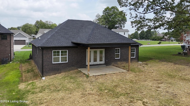 rear view of property featuring a lawn, a patio, and french doors